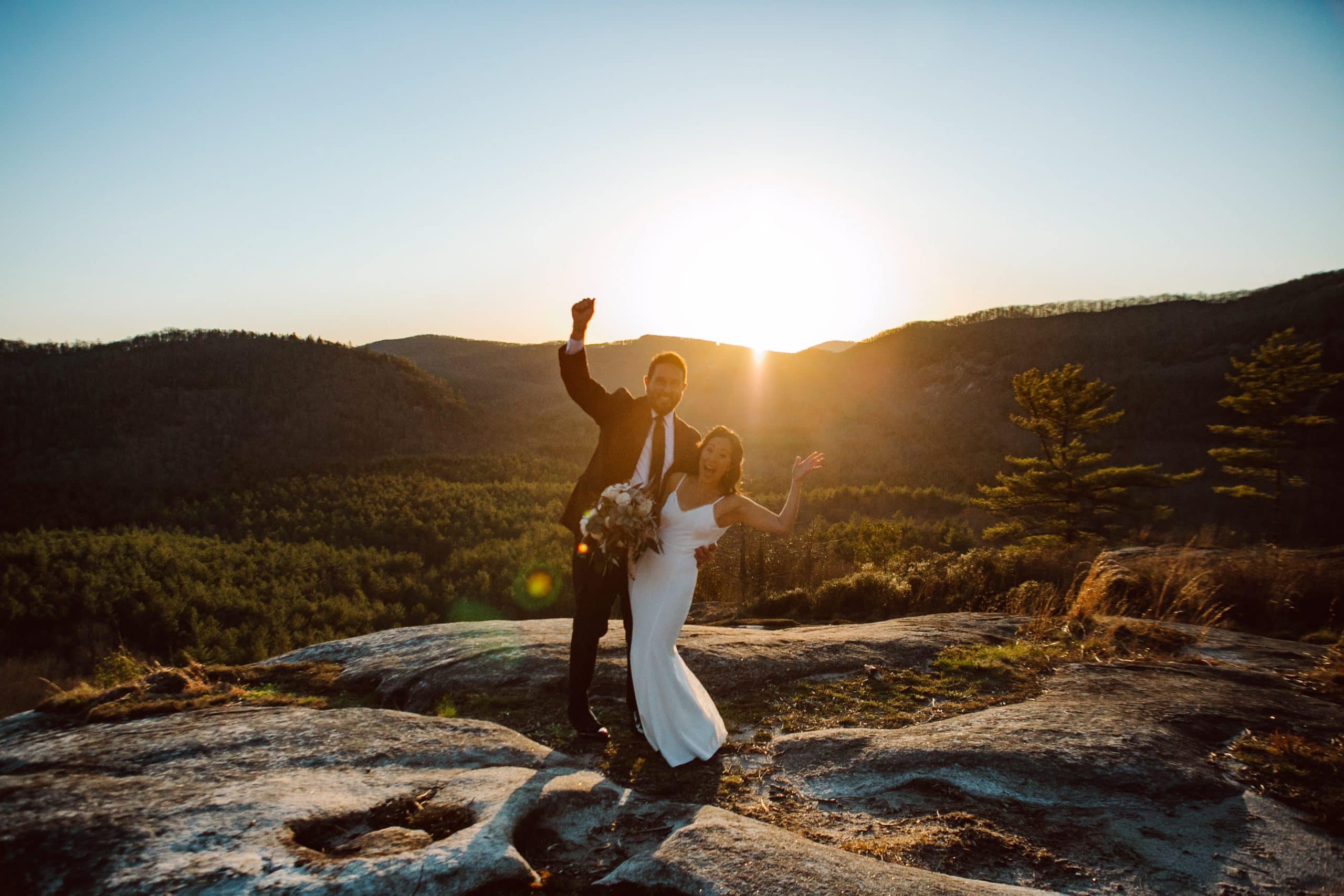 Mindy and Shane celebrate their marriage at sunset on the side of a mountain during their Asheville Adventure Elopement