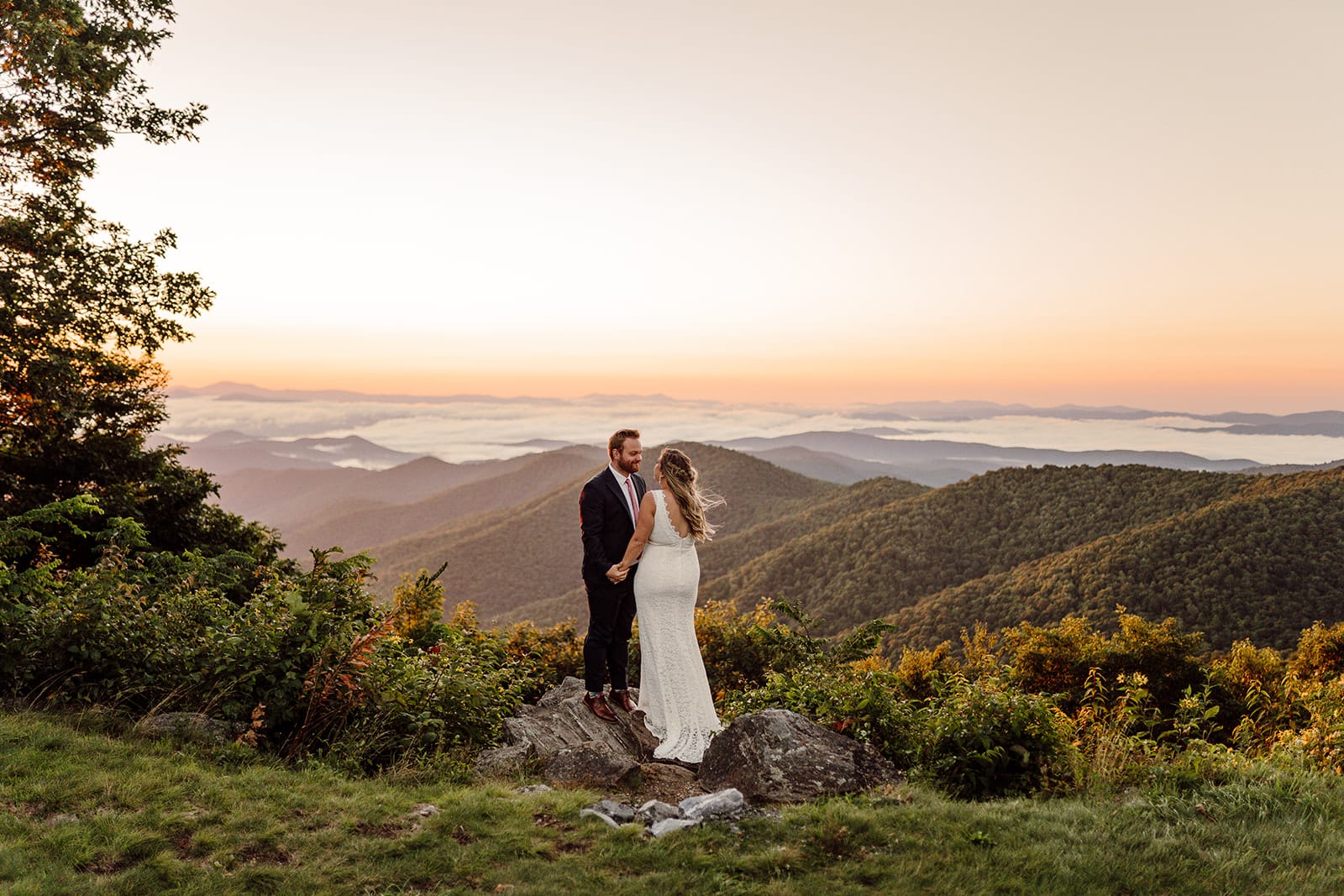 emily+travis join hands on a mountaintop off the Blue Ridge Parkway for their Asheville Wedding Day