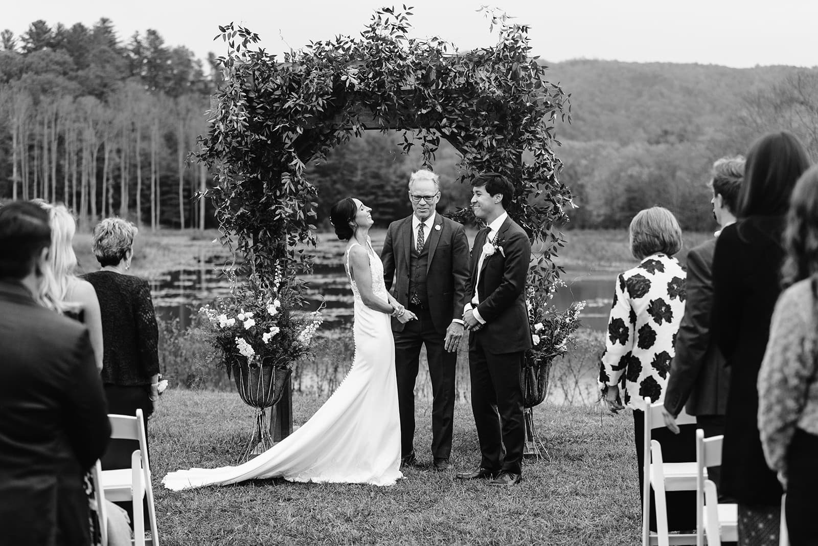 Maraia + Kyle smile together at the altar during their Brevard, NC wedding